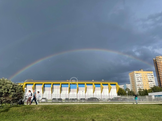 Виды города на фоне радуги..